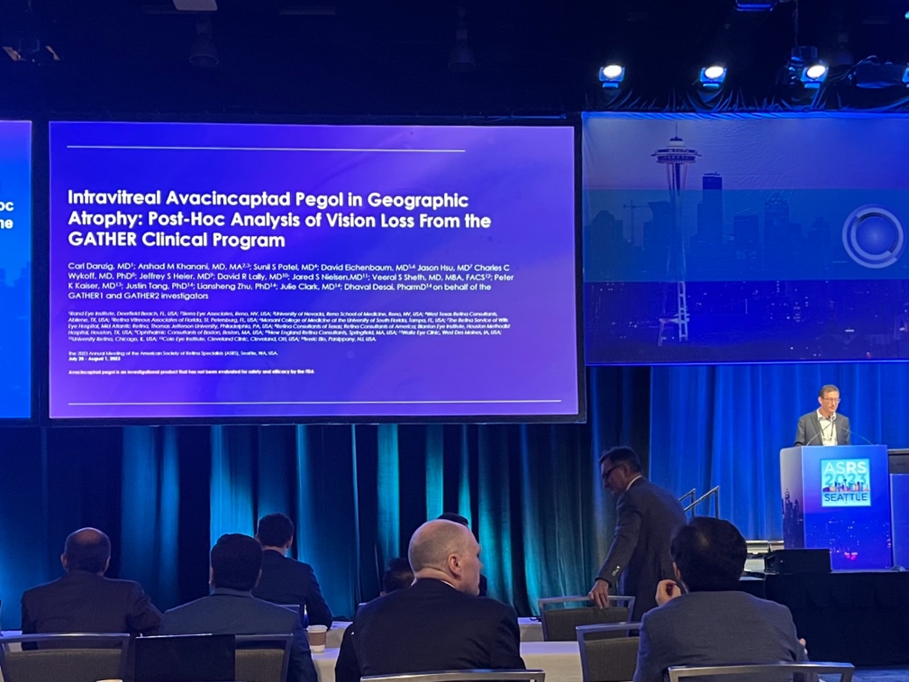 A person standing in front of a large screen  Description automatically generated