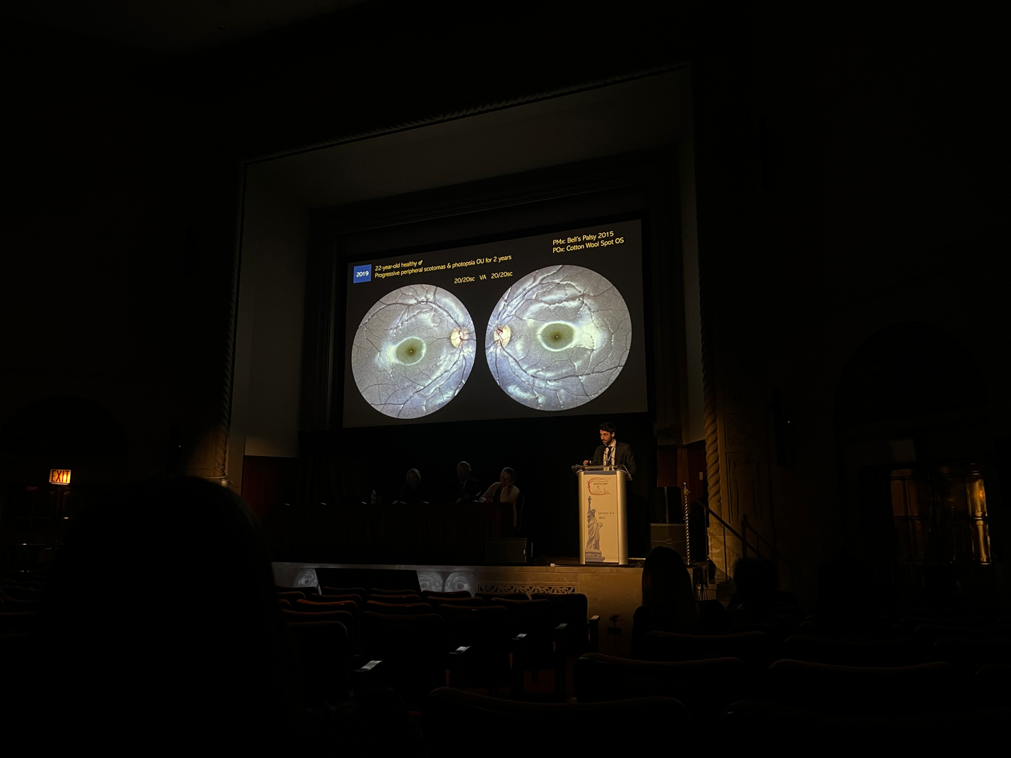 A person standing at a podium with a screen on it Description automatically generated